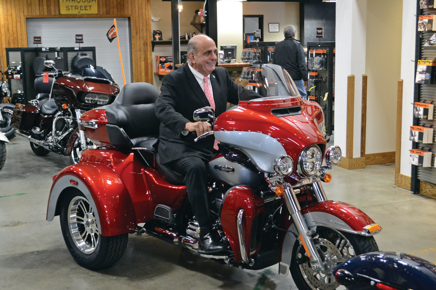 KID IN A CANDY STORE: Mayor Joseph Solomon was beaming like a child on his first bicycle behind the handlebars of this cherry red Tri-Glide, in the main showroom of Russ’ Ocean State Harley-Davidson.